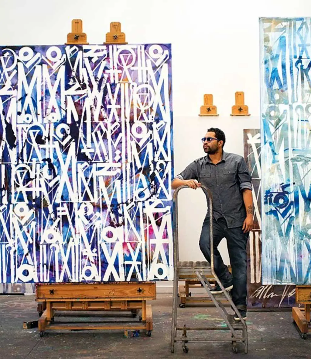 RETNA standing among his painitngs