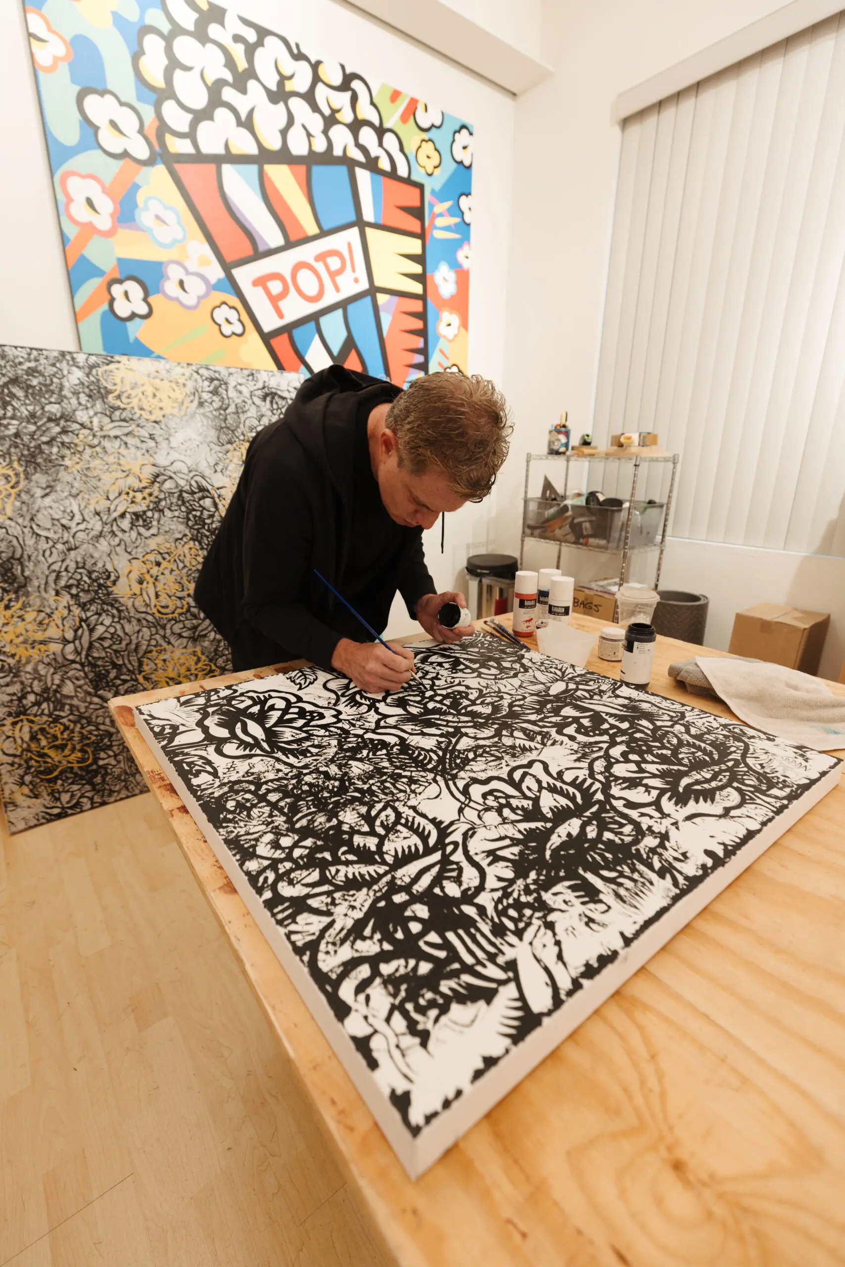 Burton Morris next to floral paintings at MASH Gallery